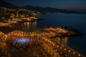 Vita notturna Albania: vista dall'alto della costa albanese con luci e gente che balla
