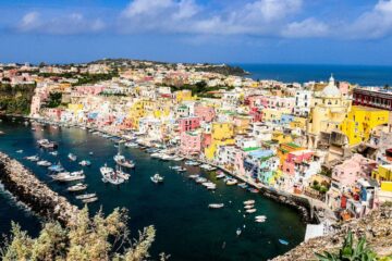 Vista panoramica del porto di Procida con case colorate e barche attraccate