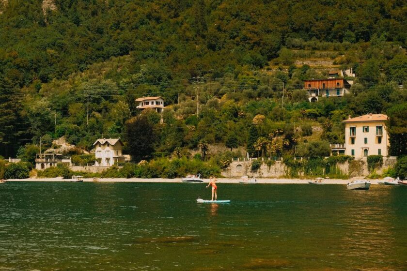 Borgo lombardo affacciato sul lago con case color pastello e barche attraccate