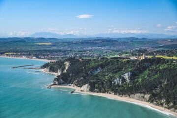 Scogliera bianca della Riviera del Conero con mare turchese e cielo limpido